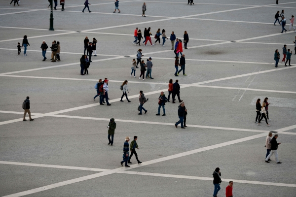 Pessoas a caminhar na Praça do Comércio (Lisboa).