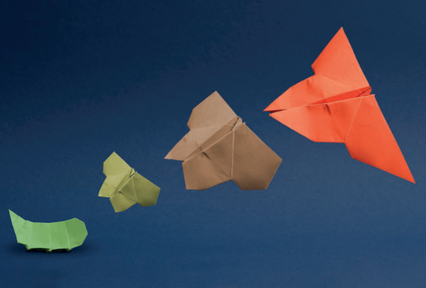 Quatro aviões em origami em cores diferentes.